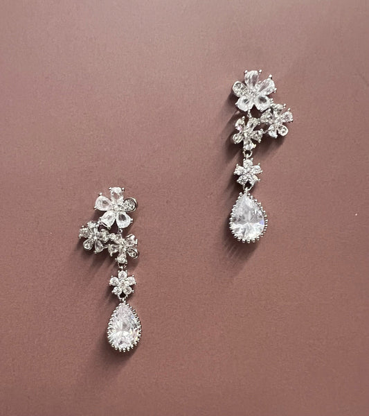 Silver CALLAcollection earrings with elegant floral design, showcasing intricate craftsmanship and shiny finish.