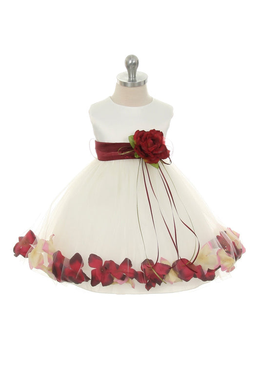 Ivory satin baby dress with flower petal design, organza sash, and delicate details, by Kid's Dream.