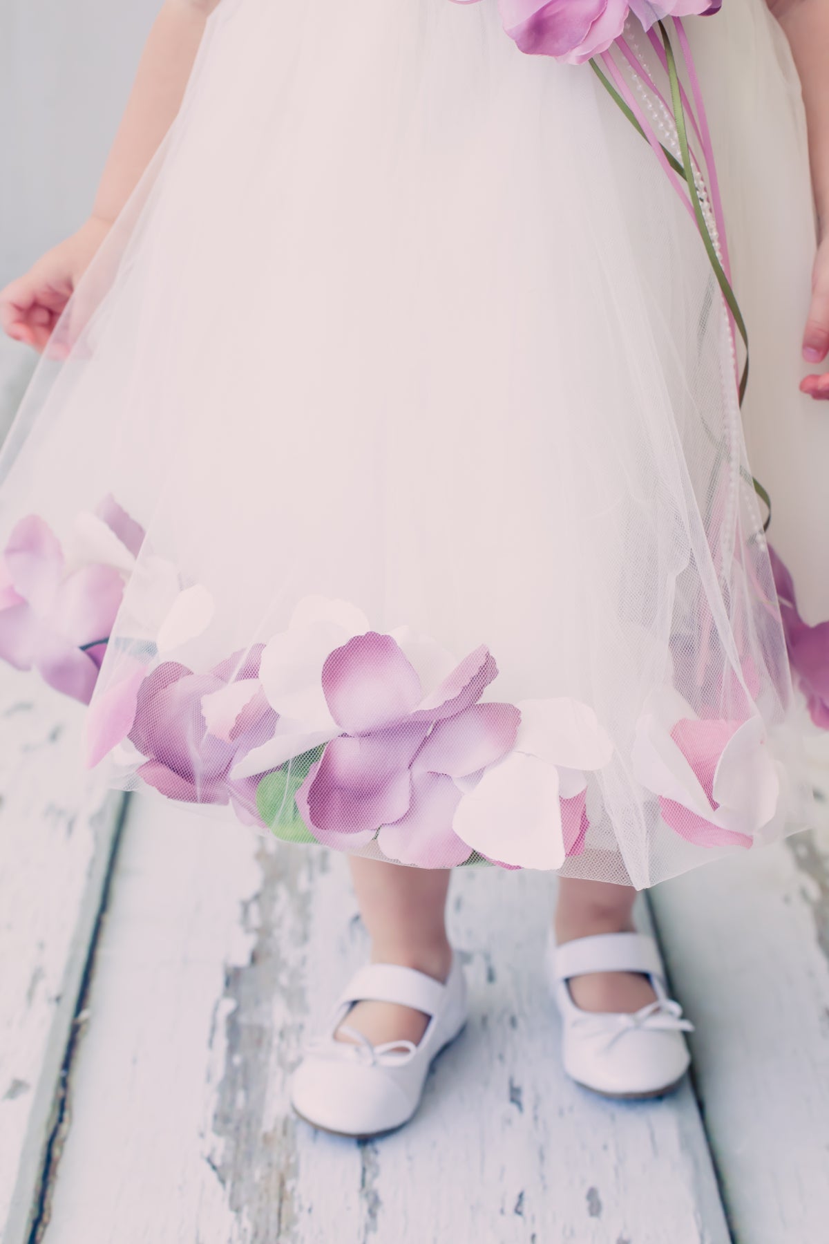 White satin flower petal baby dress with organza sash, by Kid's Dream, featuring delicate floral details and a soft, elegant design.