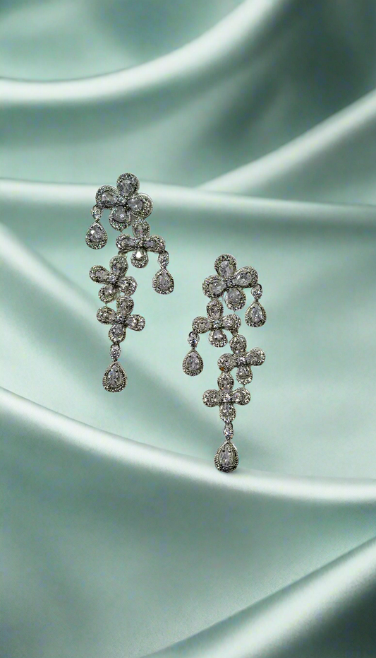 Elegant CALLAcollection earrings with intricate silver design, shown close-up against a neutral background.