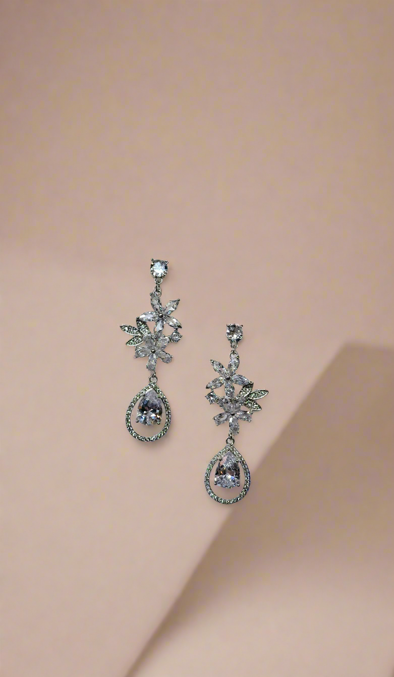 Elegant Calla Collection earrings featuring intricate silver design with gemstone accents, displayed on a neutral background.