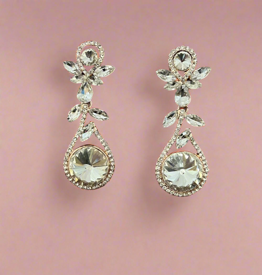 Rose gold Calla Collection earrings with large rhinestone dangling design, showcasing sparkling, eye-catching jewelry.
