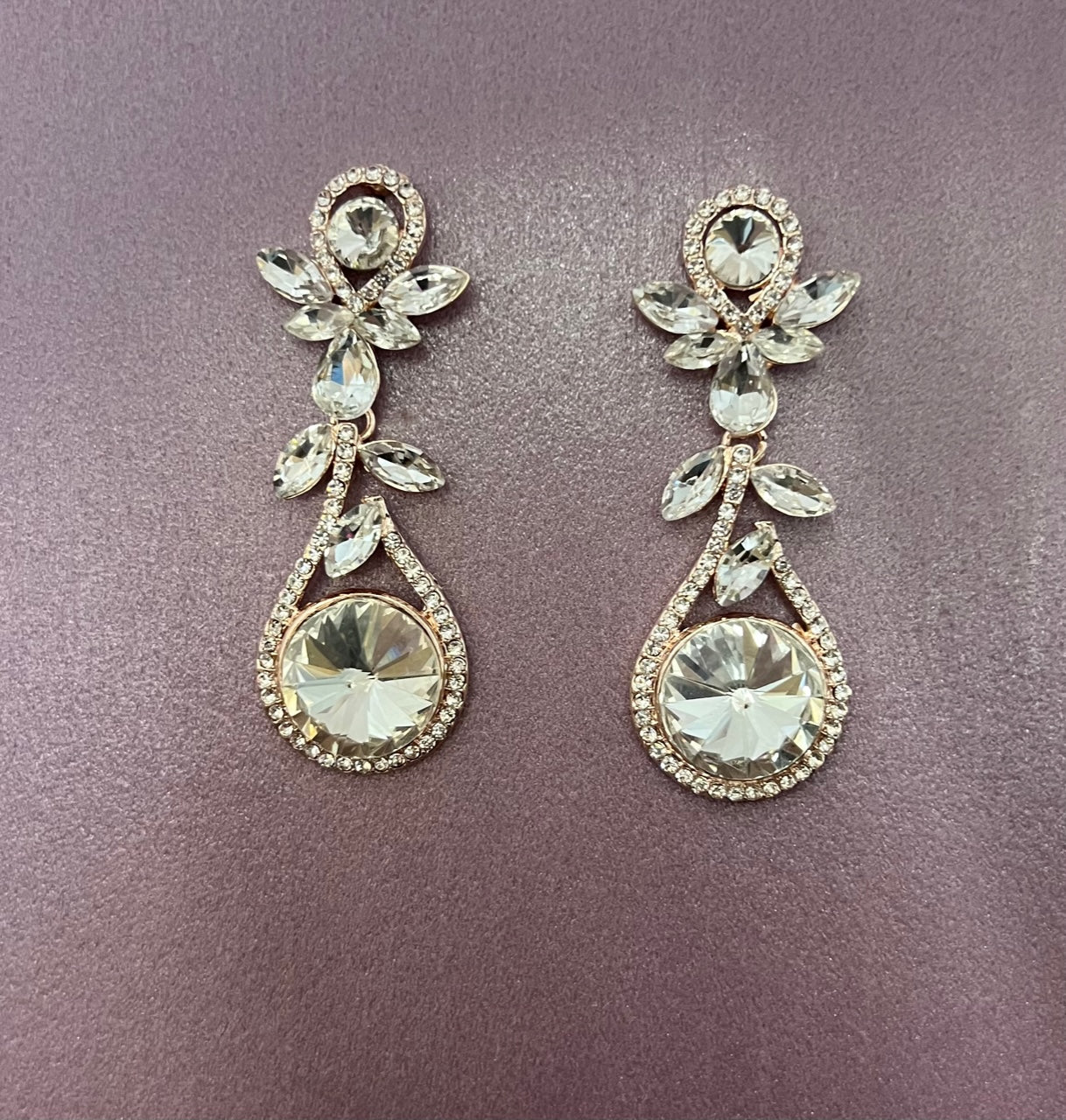 Rose gold Calla Collection earrings with large rhinestone dangling design, elegant and sparkling jewelry accessory.